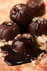 Chocolate candies with nuts, on color background