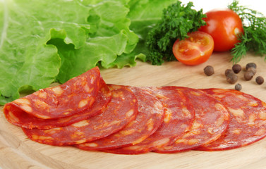 Salami slices on wooden board, close up