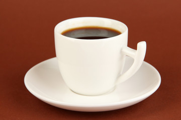 Cup of strong coffee on brown background
