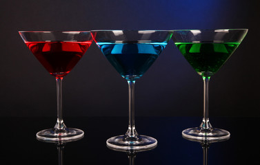 Alcoholic cocktails in martini glasses on dark blue background