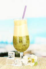 Delicious fruit smoothie on table on blue background