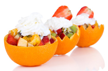 Fruit salad in hollowed-out orange isolated on white