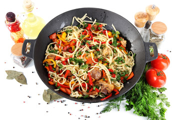 Noodles with vegetables on wok isolated on white