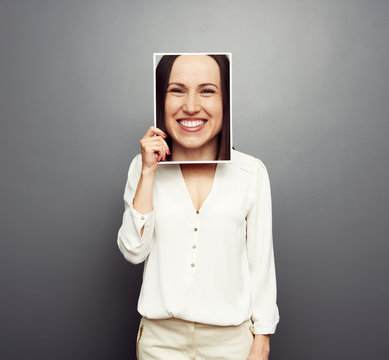 woman covering image with big happy face