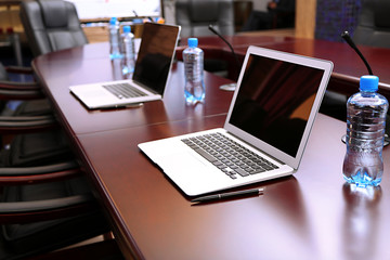 Empty conference room with laptops on table