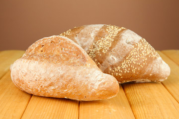 Composition with bread on wooden table, on color background