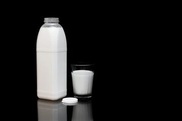 Milchflasche, geöffnet, mit einem Glas Milch