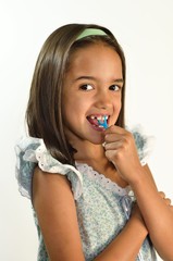Little Hispanic Girl Flossing her Teeth
