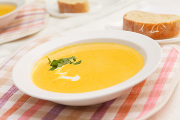 Pumpkin soup in white bowl