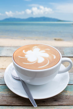 Coffee cup on terrace facing seascape