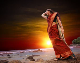 Fotobehang Woman on the ocean in red sari © Dmitry Perov