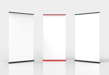 Three blank roll-up poster banner displays. Two black, one red.