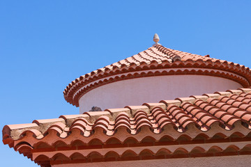 Small statue on the red tiled roof