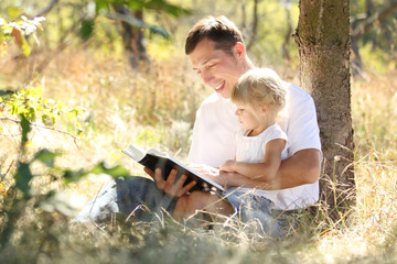 father with his little daughter reads the Bible