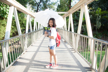 Young woman holding a white umbrella.