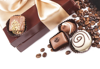 brown box with candies and golden tape, coffee grains on a white