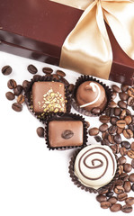 brown box with candies and golden tape, coffee grains on a white