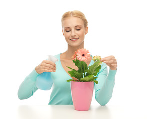 woman holding pot with flower and spray bottle
