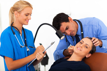 doctor examining woman's ear