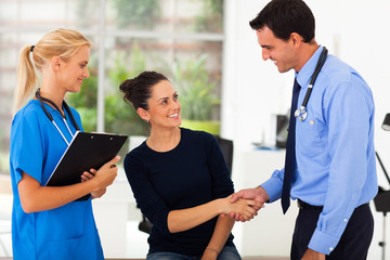 woman handshaking with doctor after checkup