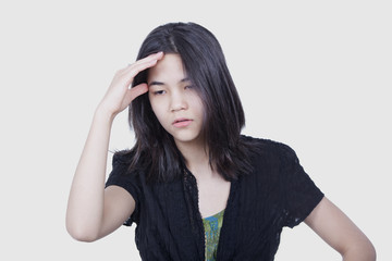 Young biracial teen girl massaging temple, face stressed or havi