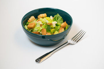 traditional salad with croutons  in a green bowl with a fork