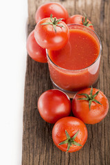 tomato juice and fresh tomatoes on a wooden board
