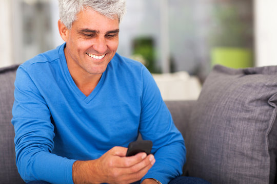 Middle Aged Man Reading Emails On Smart Phone