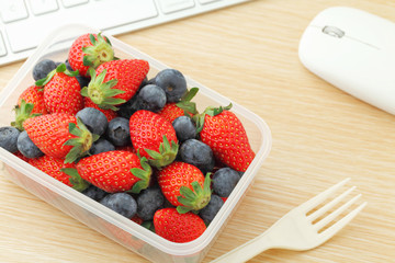 Health lunch with strawberry and blueberry mix in office