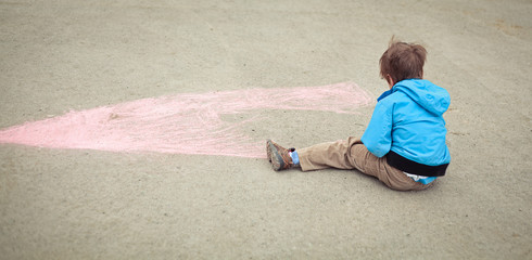 Boy drawing on road