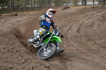 MX racer on a motorcycle in the reversal sandy track