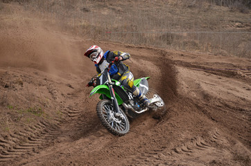 MX motorcycle with rider shoots out of a turn