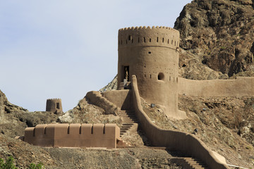 Watchtower with steps and mountains in Old Muscat