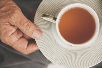 a hand ilfts a cup of tea