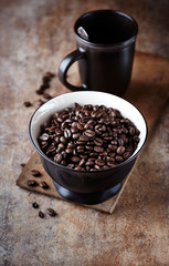 Dark coffee beans in a ceramic bowl