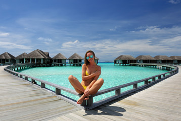 Woman on a beach jetty at Maldives