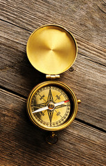 Antique compass over wooden background