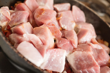 Pork in frying pan. Selective focus