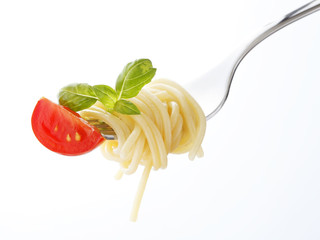 Spaghetti pasta with tomato and basil on fork