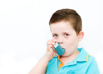 little boy using his asthma pump