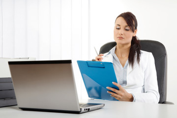 Young businesswoman holding coffee while at work
