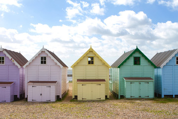 Fototapeta na wymiar Traditional British beach huts on a bright sunny day
