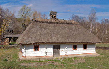 Fototapeta na wymiar Ancient traditional ukrainian rural cottage with a straw roof
