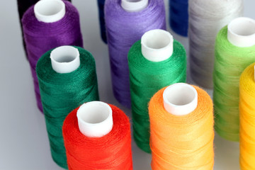 Many-coloured bobbins of thread closeup