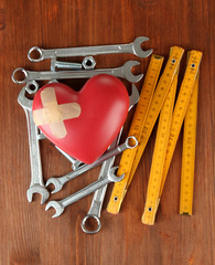 Heart and tools. Concept: Renovation of heart. On wooden
