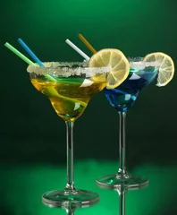  Gele en blauwe cocktails in glazen op gekleurde achtergrond © Africa Studio