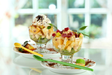 Fruit salad in a sundae dish on window background
