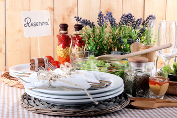 Table setting on checkered tablecloth on wooden background