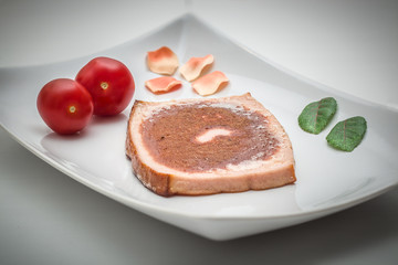 Gebratener Leberkäse mit Tomaten angerichtet