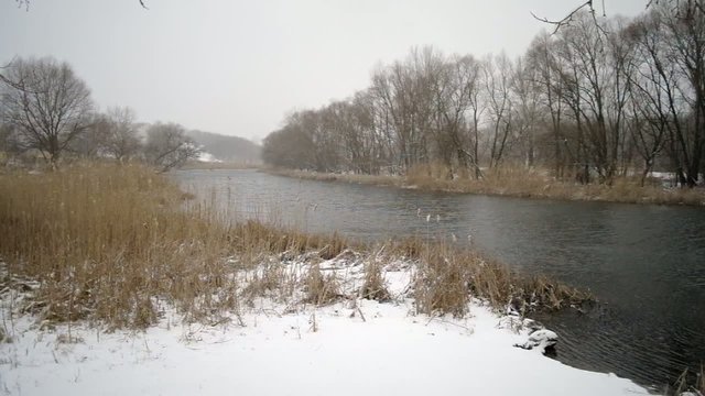 Type on the winter river with a falling snow